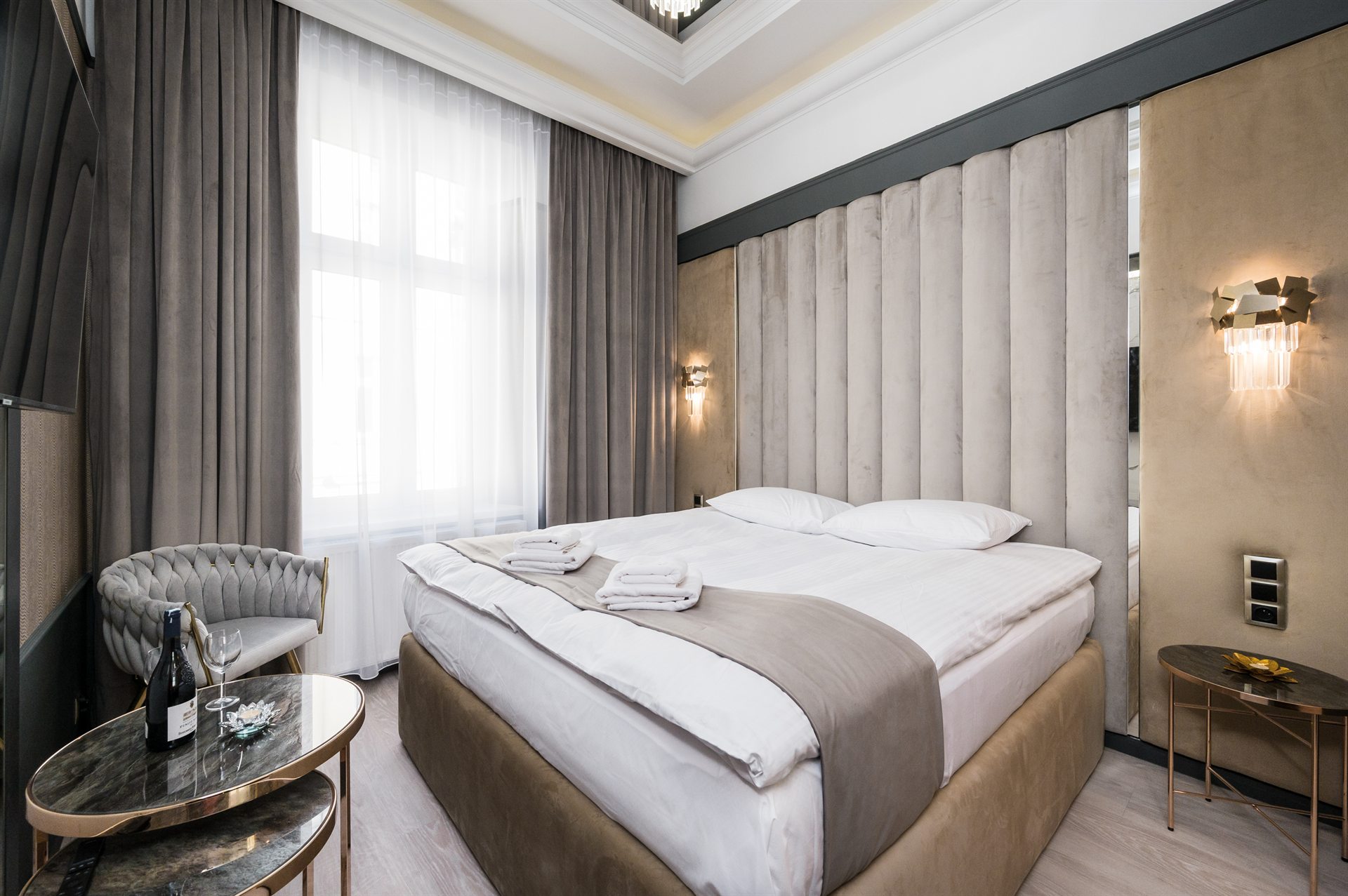 Nowoczesna sypialnia z dużym łóżkiem, szaro-beżowe tkaniny i eleganckie lampy