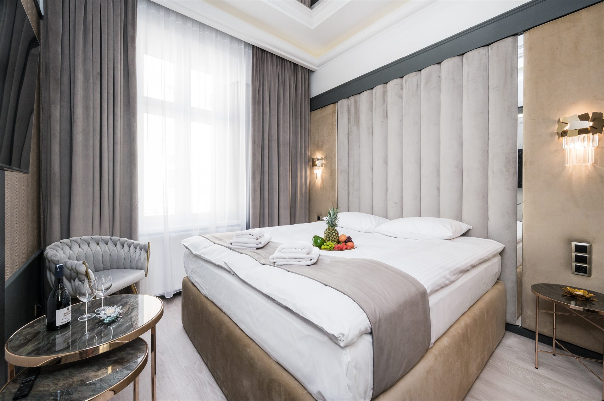 Nowoczesna sypialnia hotelowa z dużym łóżkiem i owocami na pościeli