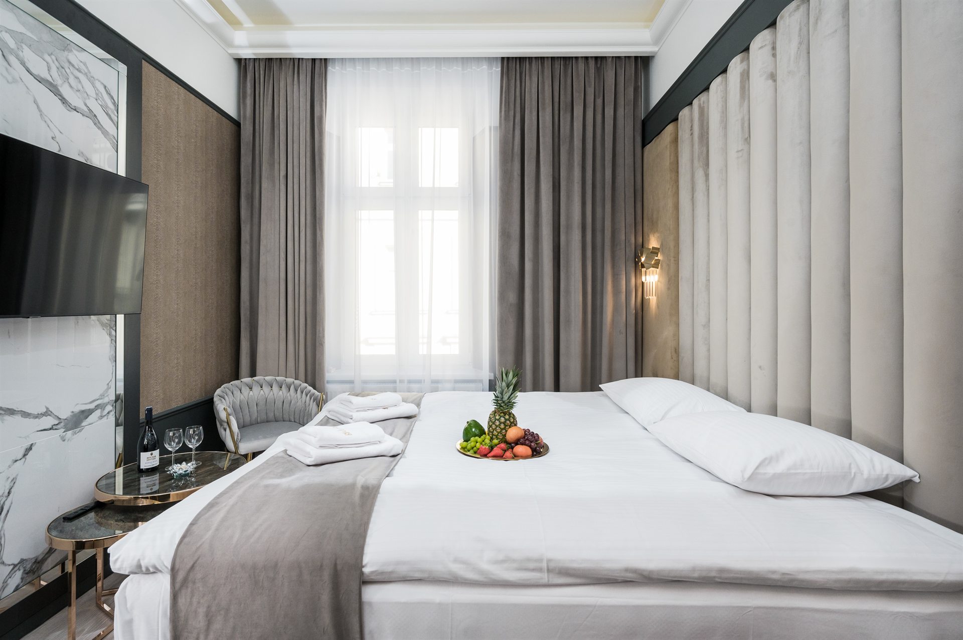 Nowoczesny pokój hotelowy z dużym łóżkiem i owocami na stoliku