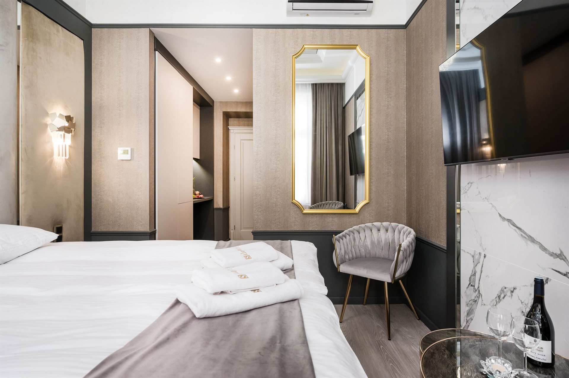 Nowoczesny pokój hotelowy z eleganckim łóżkiem i lustrem w złotej ramie