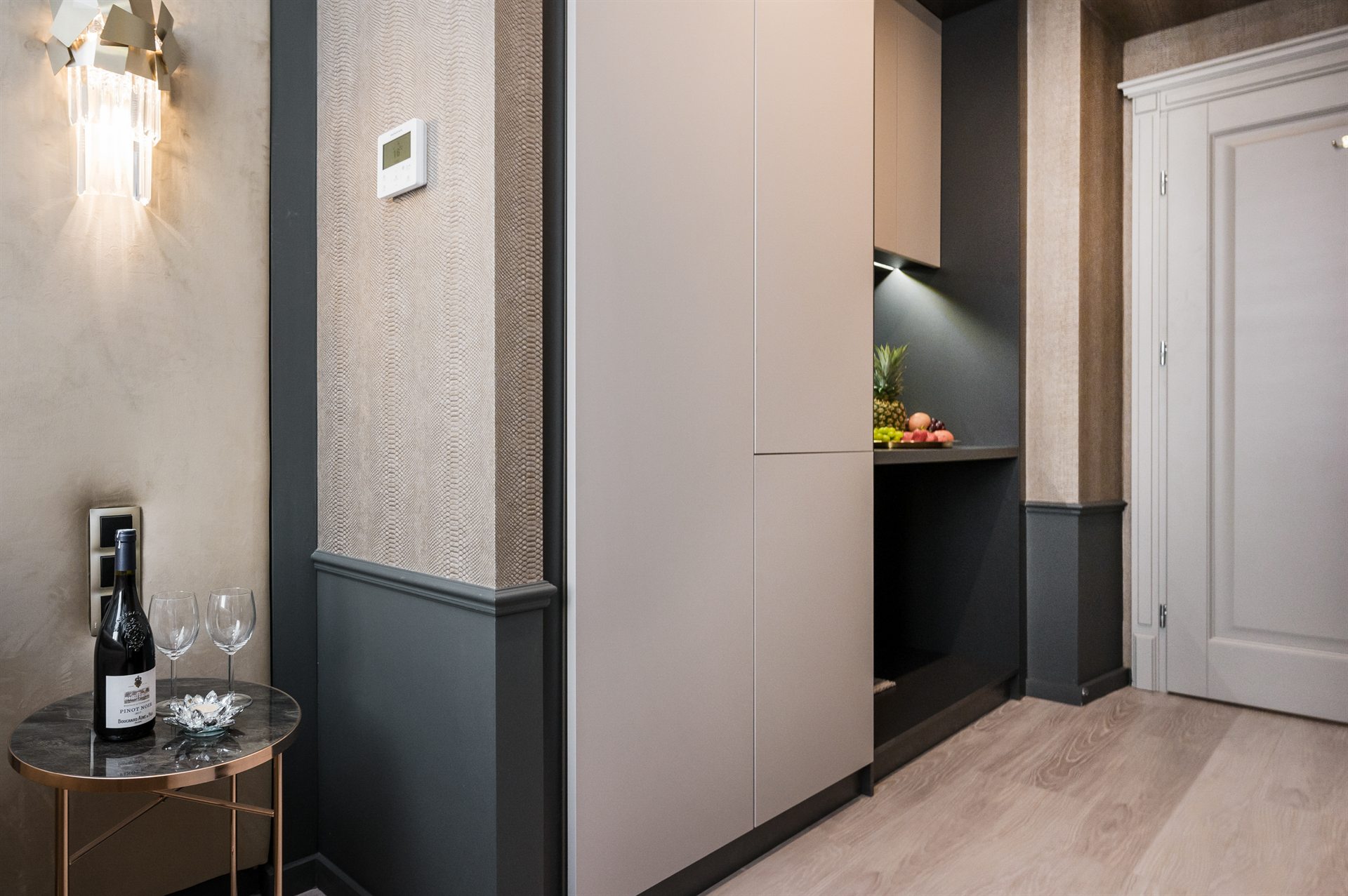 Elegancka kuchnia z szarymi meblami, stół z winem i owocami