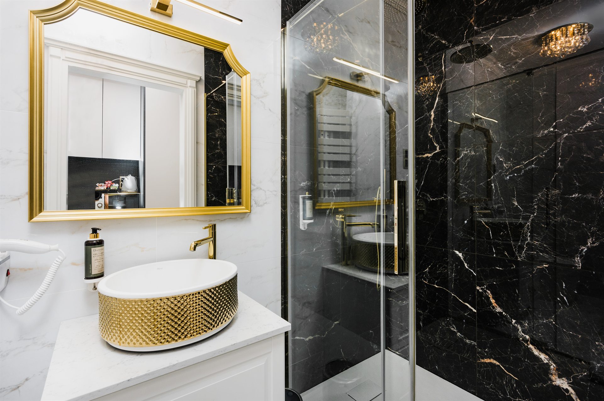 Elegancka łazienka z czarnym marmurem i złotymi akcentami, nowoczesna umywalka