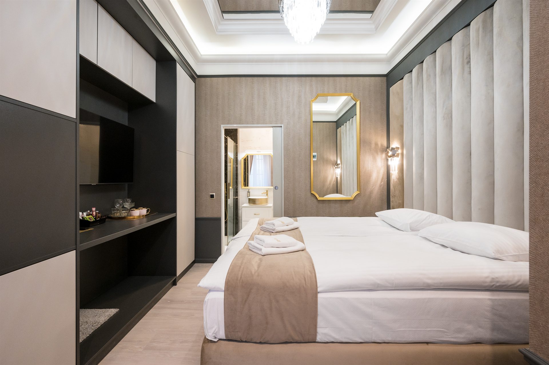 Nowoczesna sypialnia z podwójnym łóżkiem, telewizorem i eleganckim lustrem