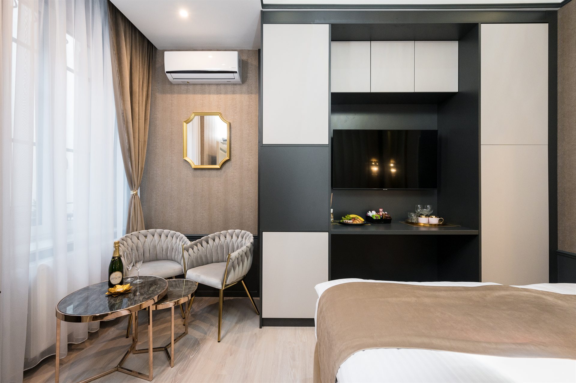 Elegancki pokój hotelowy z okrągłym stolikiem i sofą w odcieniach szarości