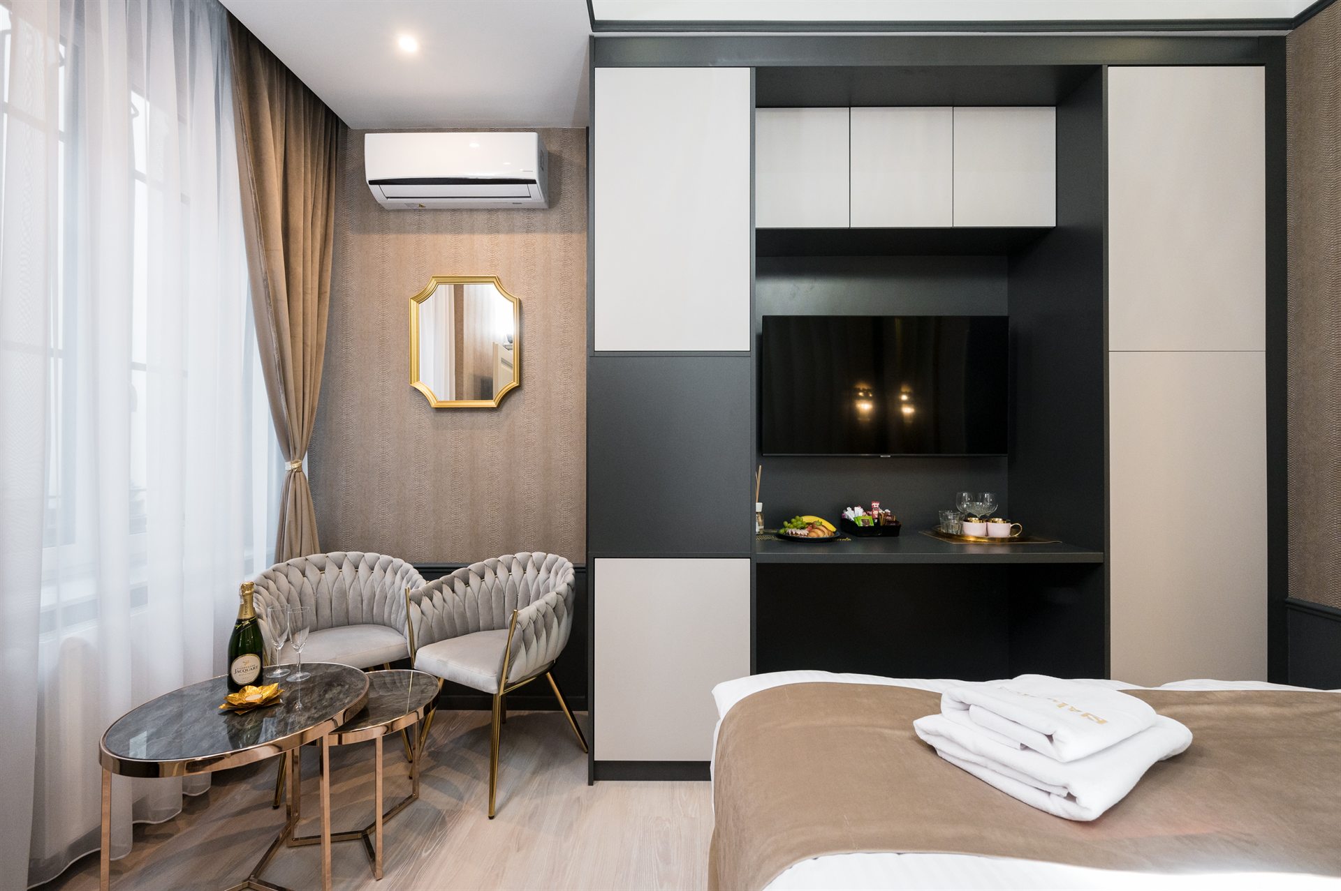 Nowoczesny pokój hotelowy z eleganckim wystrojem, wygodnymi fotelami i telewizorem