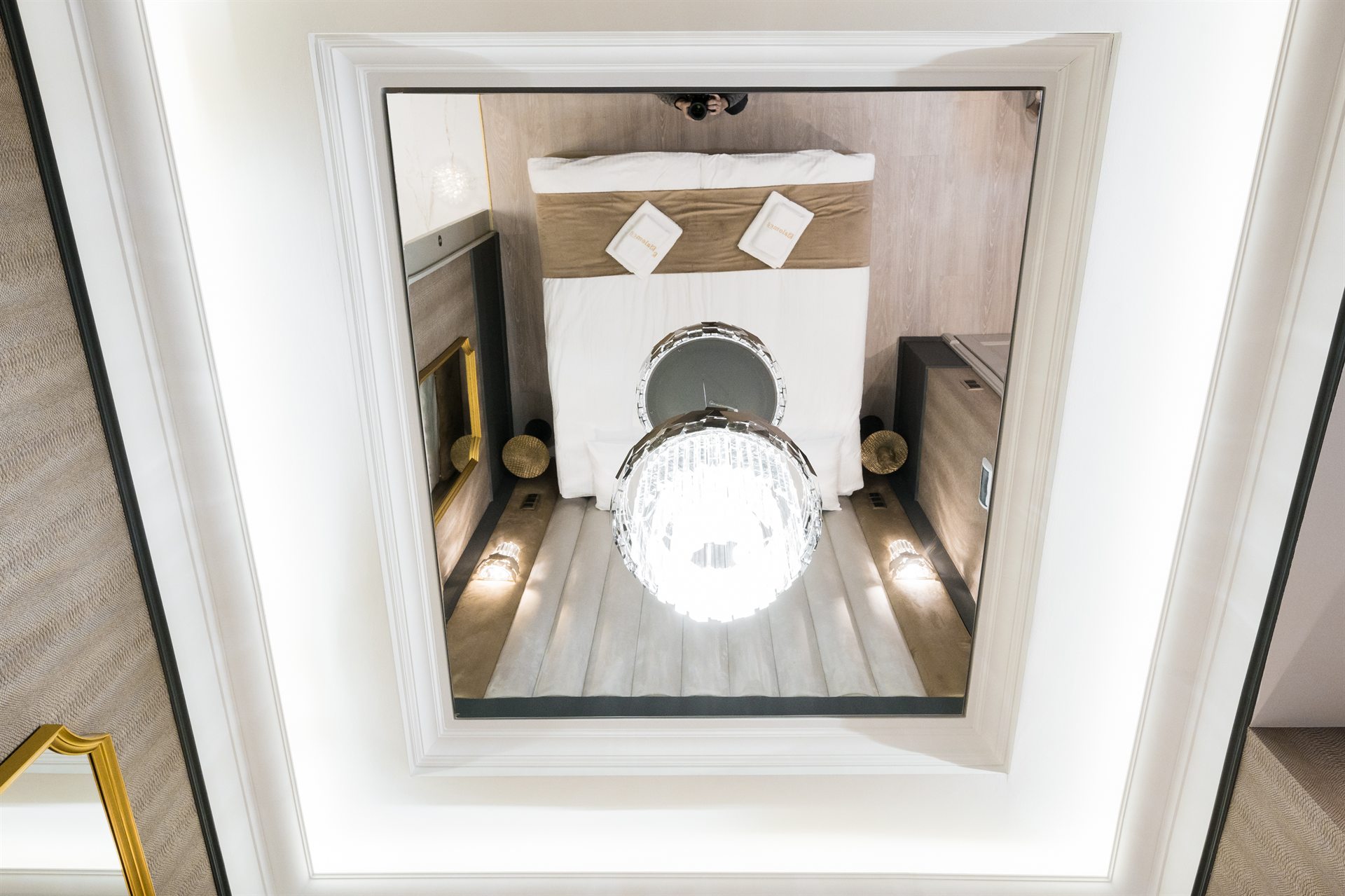 Luksusowa sypialnia z łóżkiem, lustrem i eleganckim żyrandolem