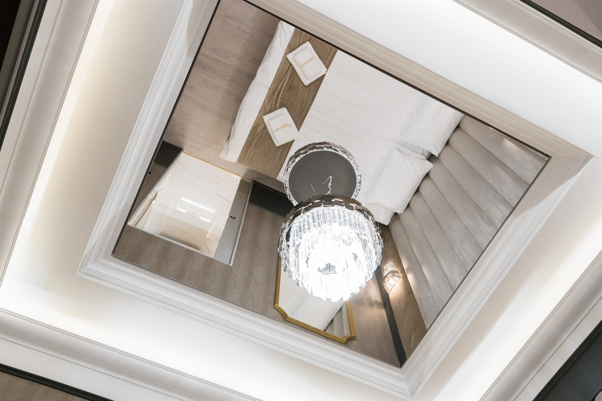 Odbicie eleganckiego wnętrza hotelowego z kryształowym żyrandolem