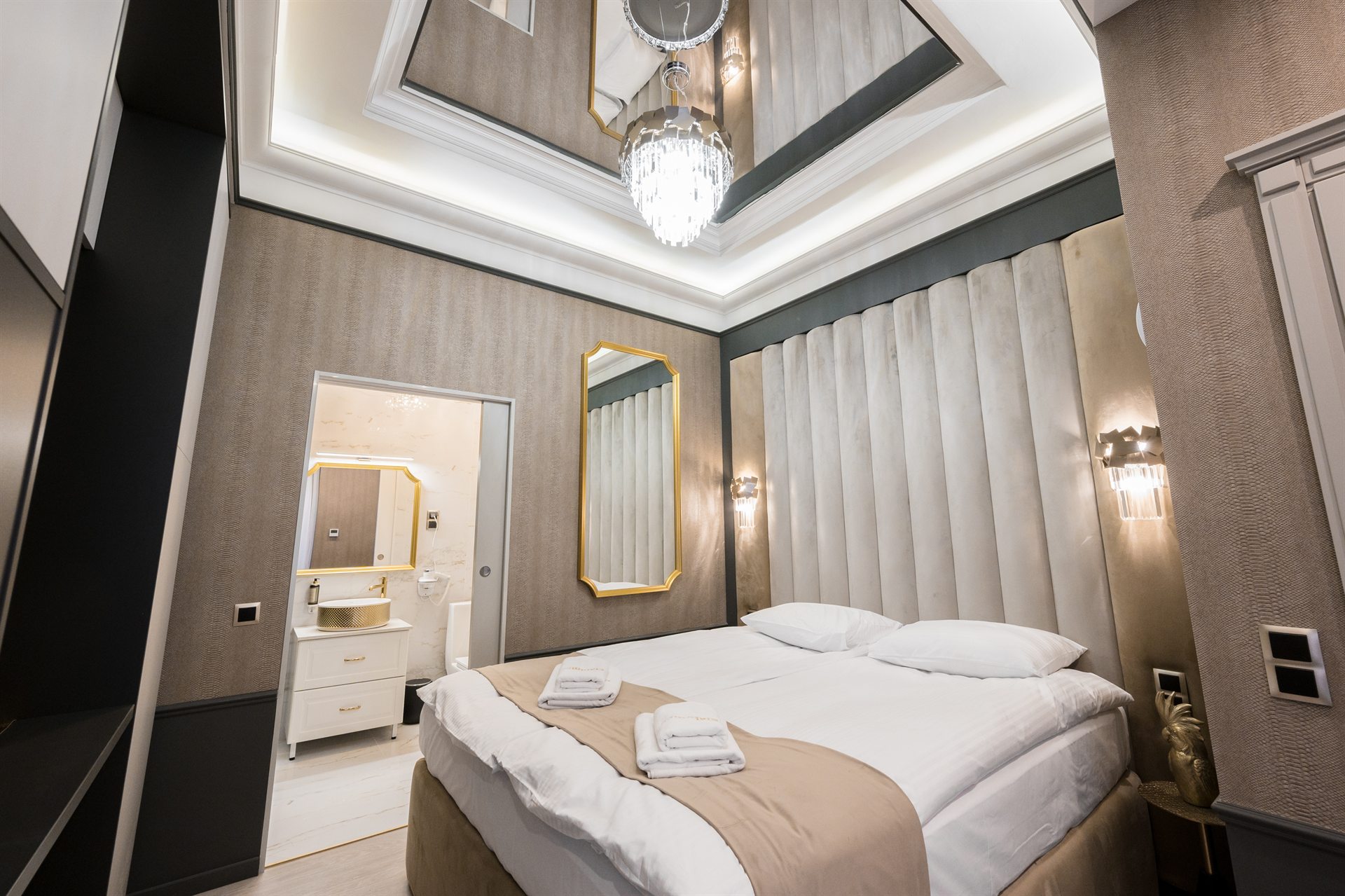 Przytulna sypialnia z dużym łóżkiem, eleganckimi detalami i lustrem