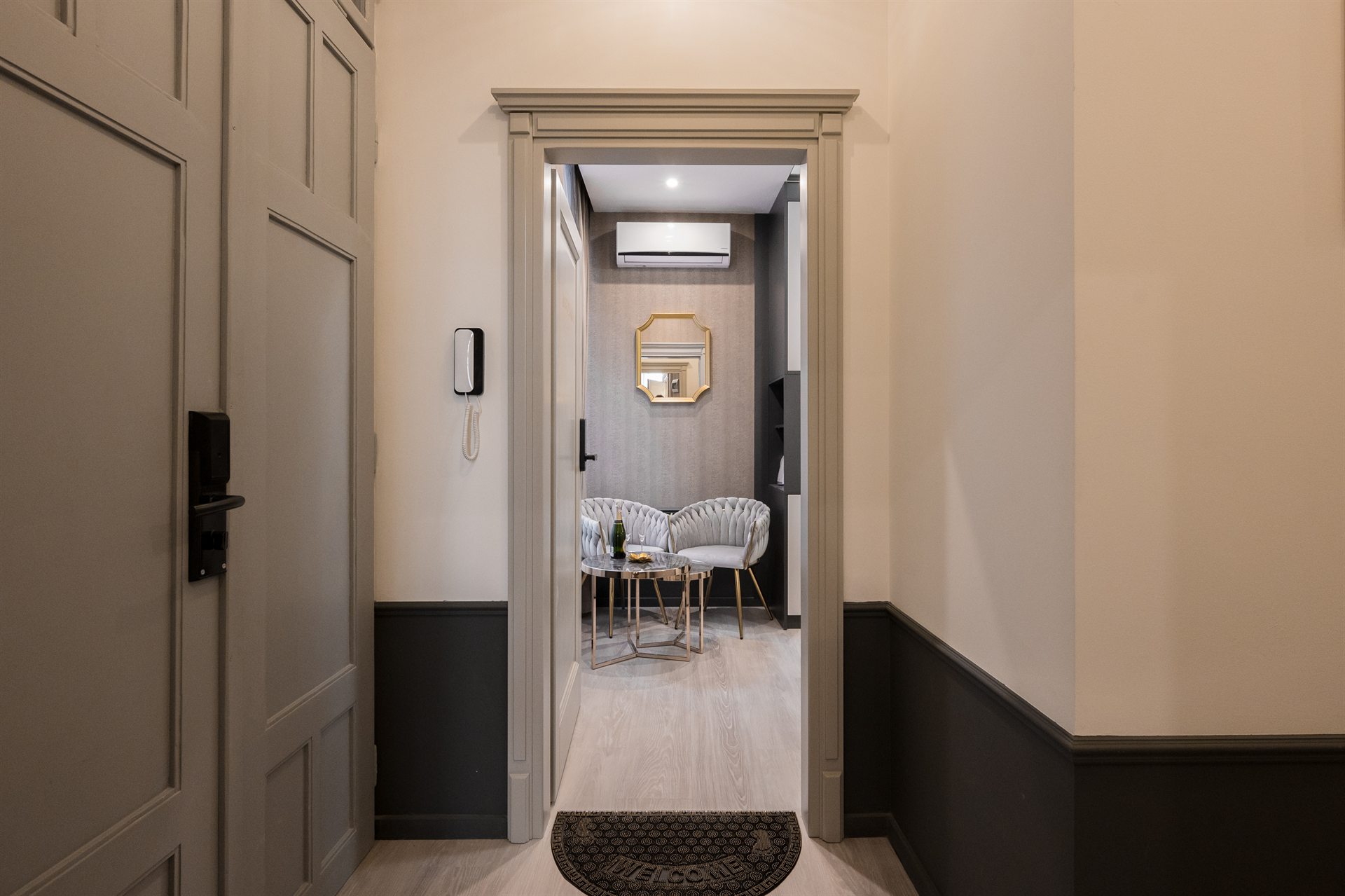 Przytulny korytarz prowadzący do eleganckiego salonu z fotelami