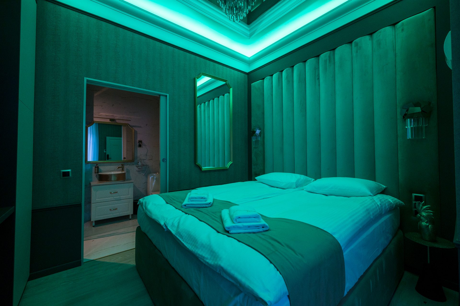 Nowoczesna sypialnia z zielonym oświetleniem i podwójnym łóżkiem