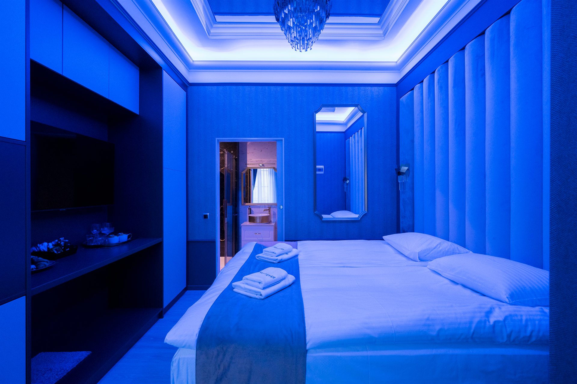 Świecąca niebieskim światłem nowoczesna sypialnia z podwójnym łóżkiem