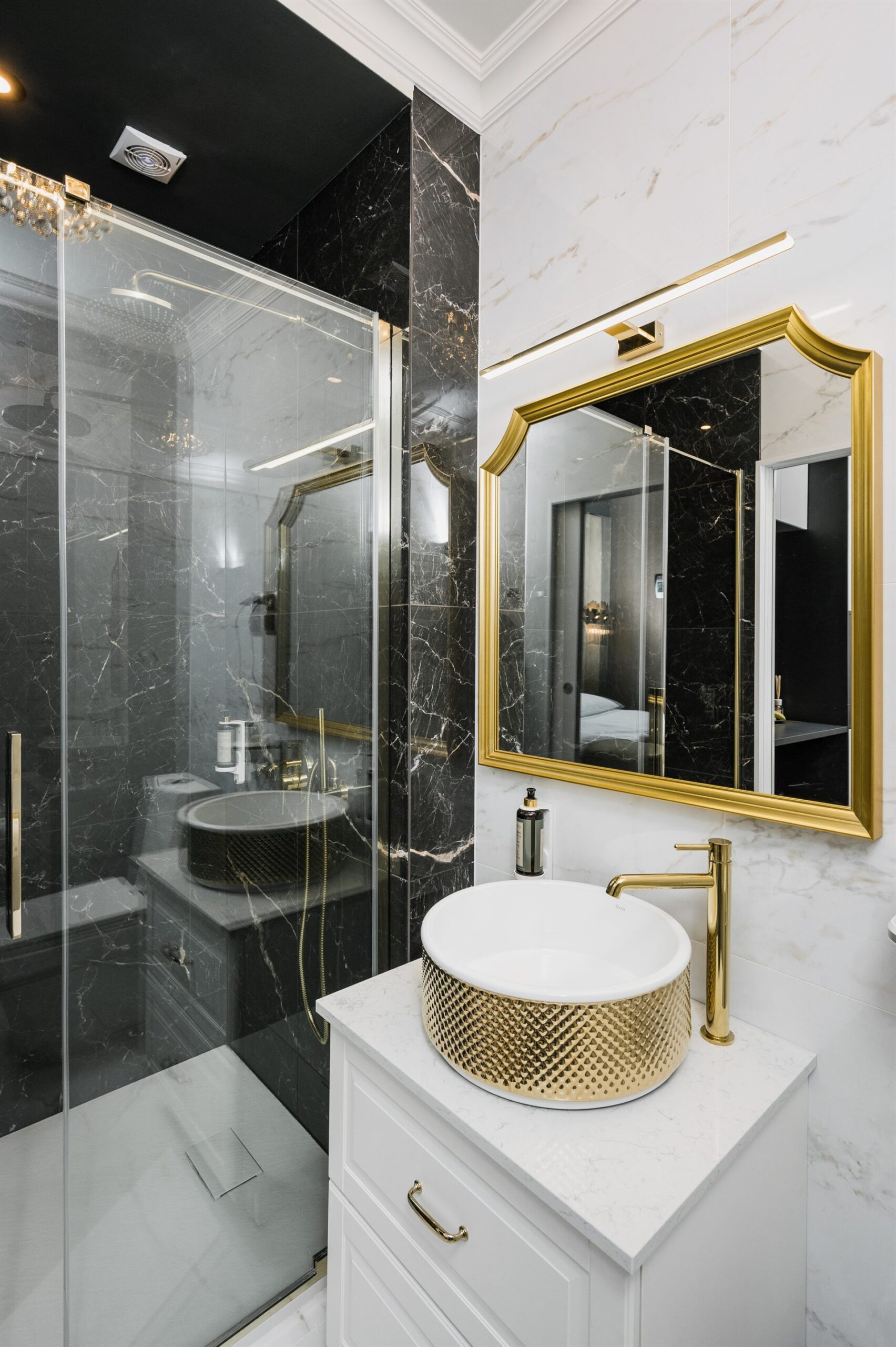 Elegancka łazienka z czarnymi i złotymi akcentami, umywalka na blacie