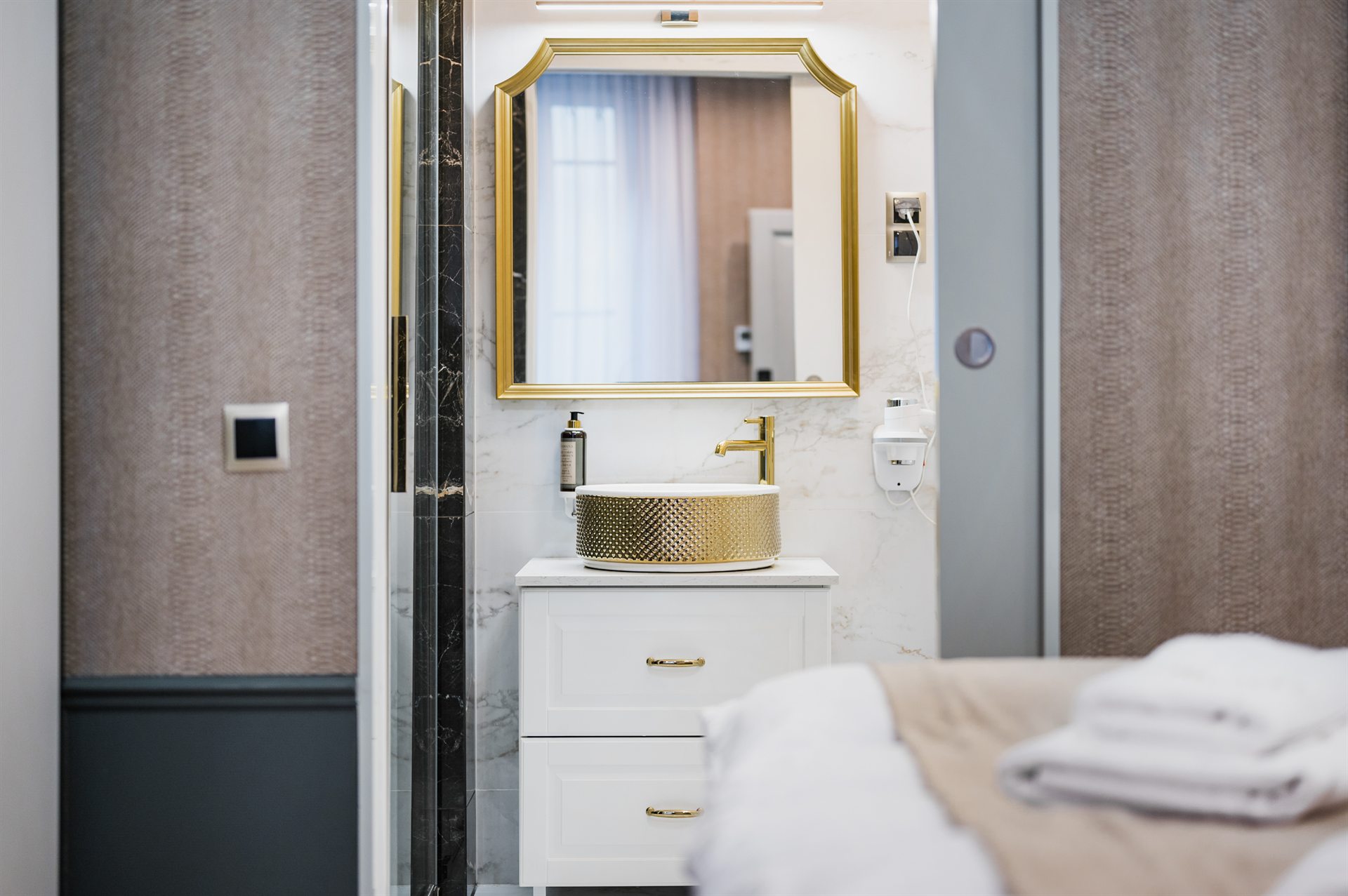 Nowoczesna łazienka z umywalką w złotym kolorze i eleganckim lustrem