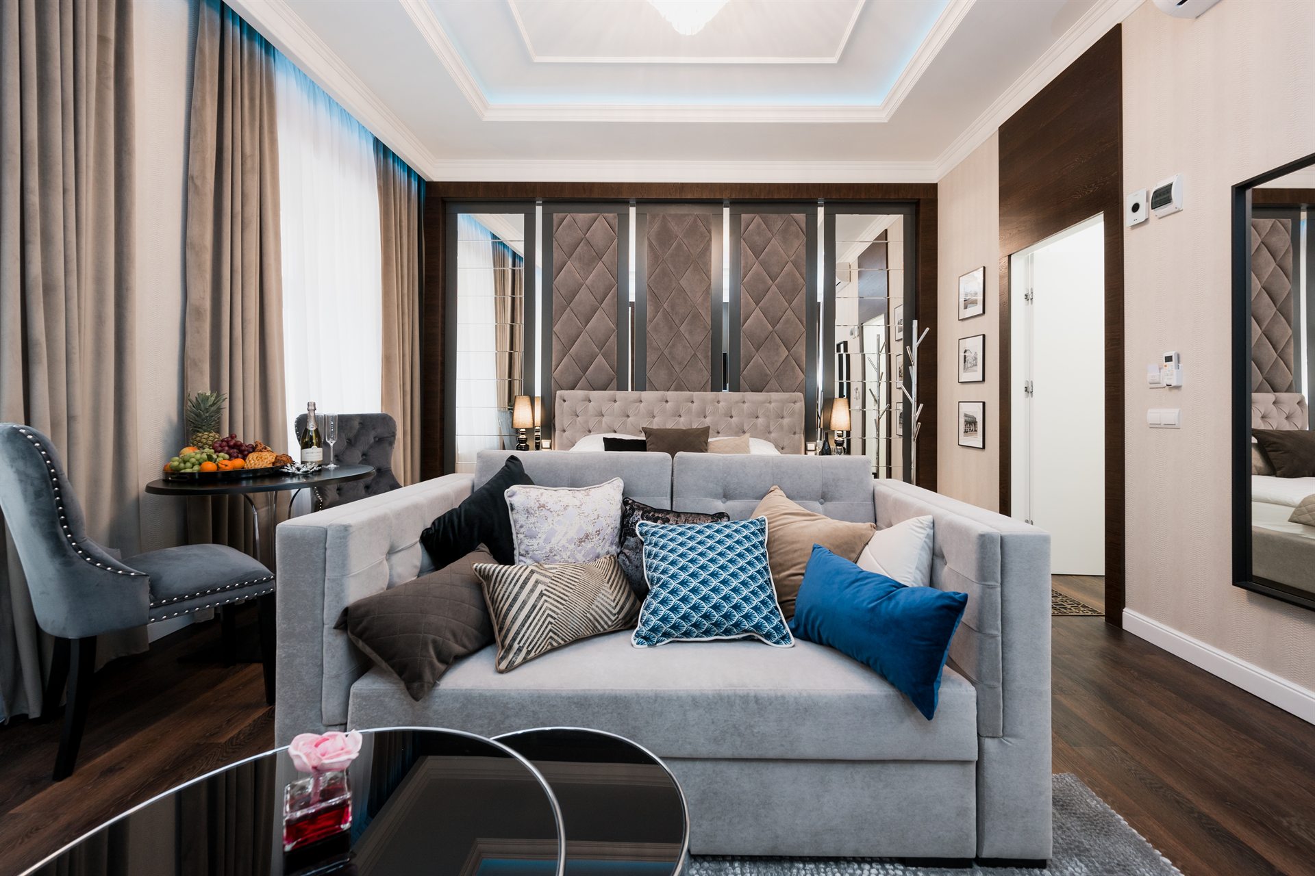 Stylowy salon z szarym sofa oraz kolorowymi poduszkami, elegancka aranżacja