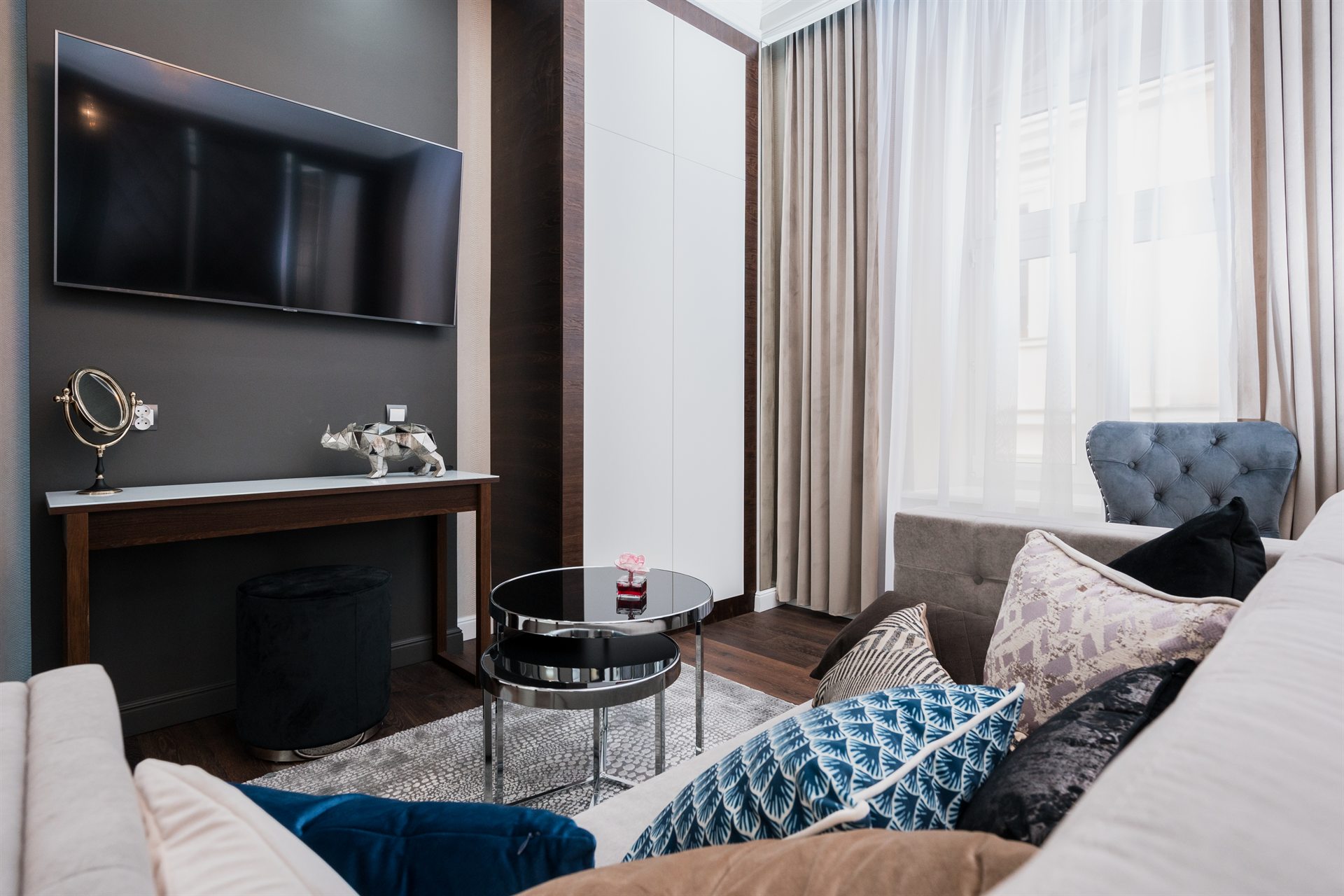 Nowoczesny pokój dzienny z telewizorem, sofą i stylowymi poduszkami