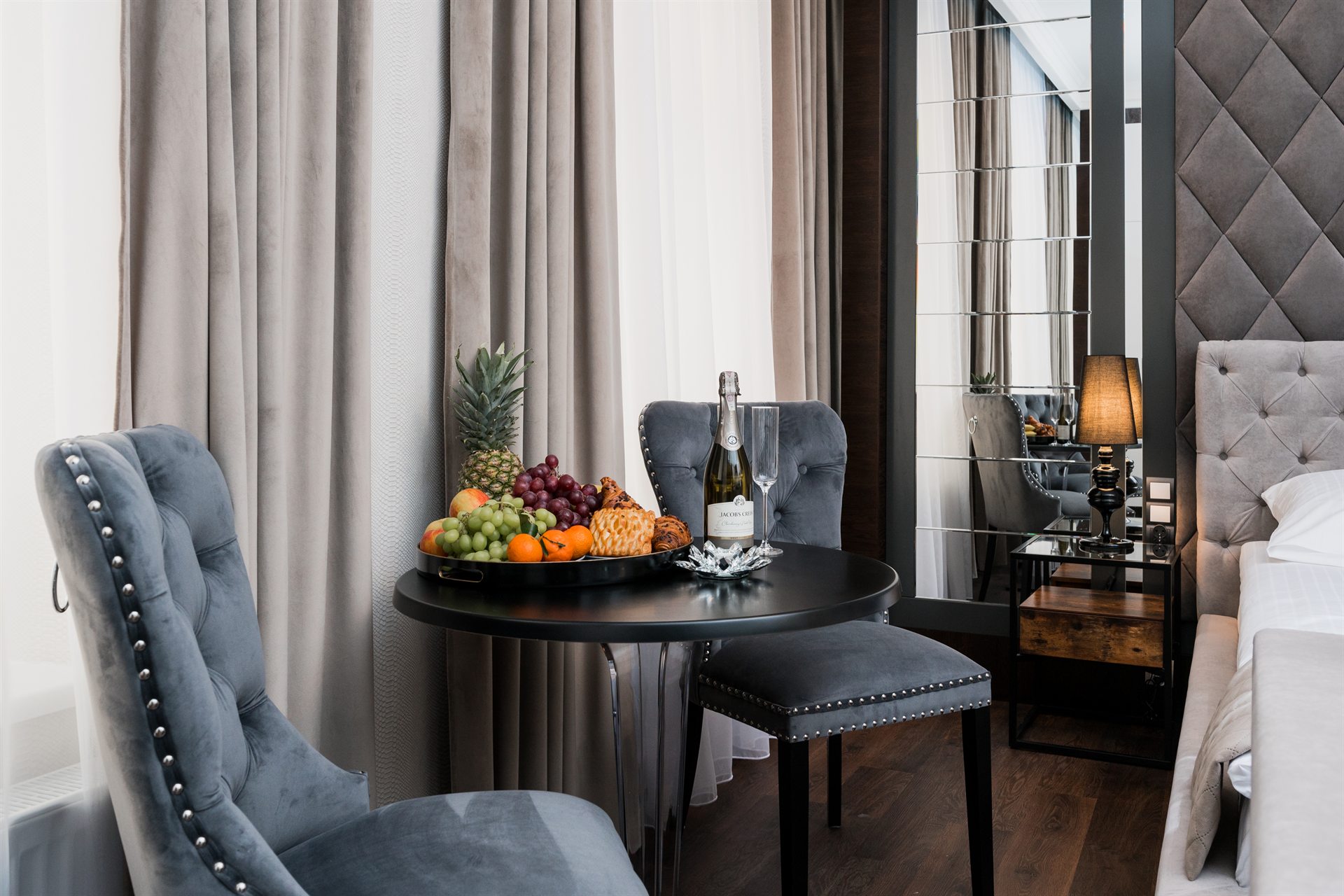 Stół z owocami, butelką szampana i szklankami w eleganckim pokoju