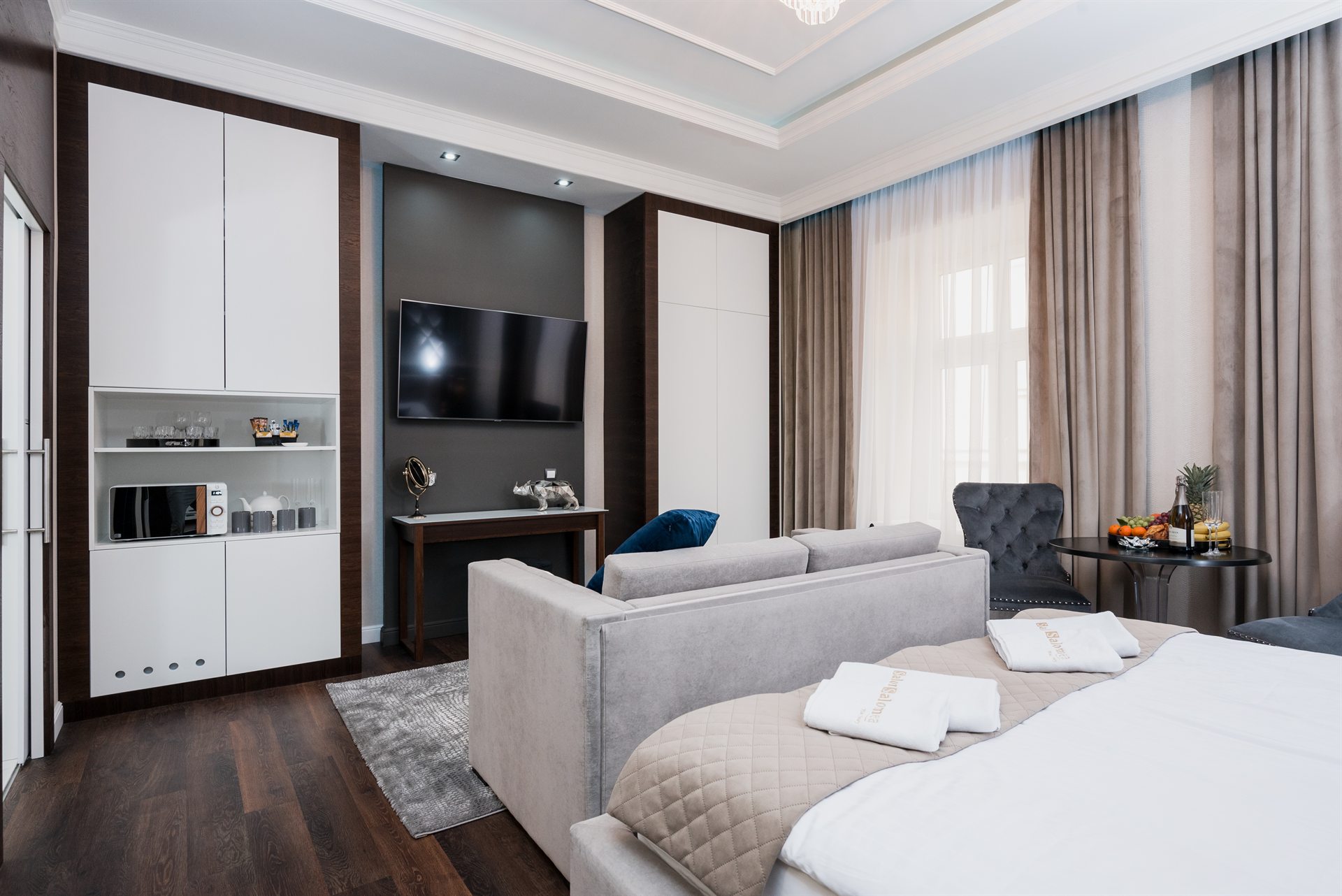 Nowoczesny pokój z telewizorem, sofą, łóżkiem i strefą wypoczynkową