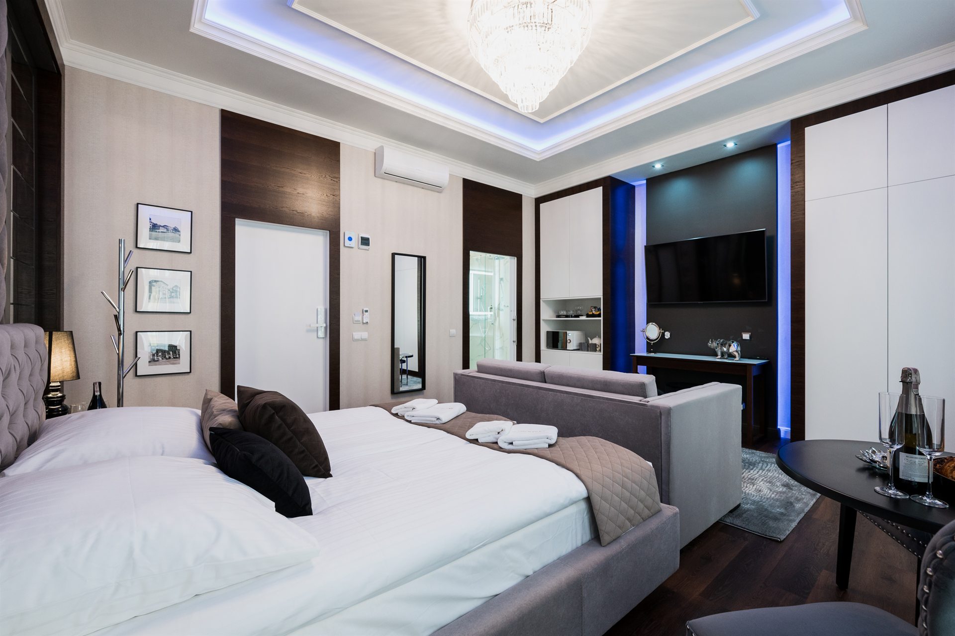 Elegancka sypialnia z nowoczesnymi meblami, łóżkiem i telewizorem