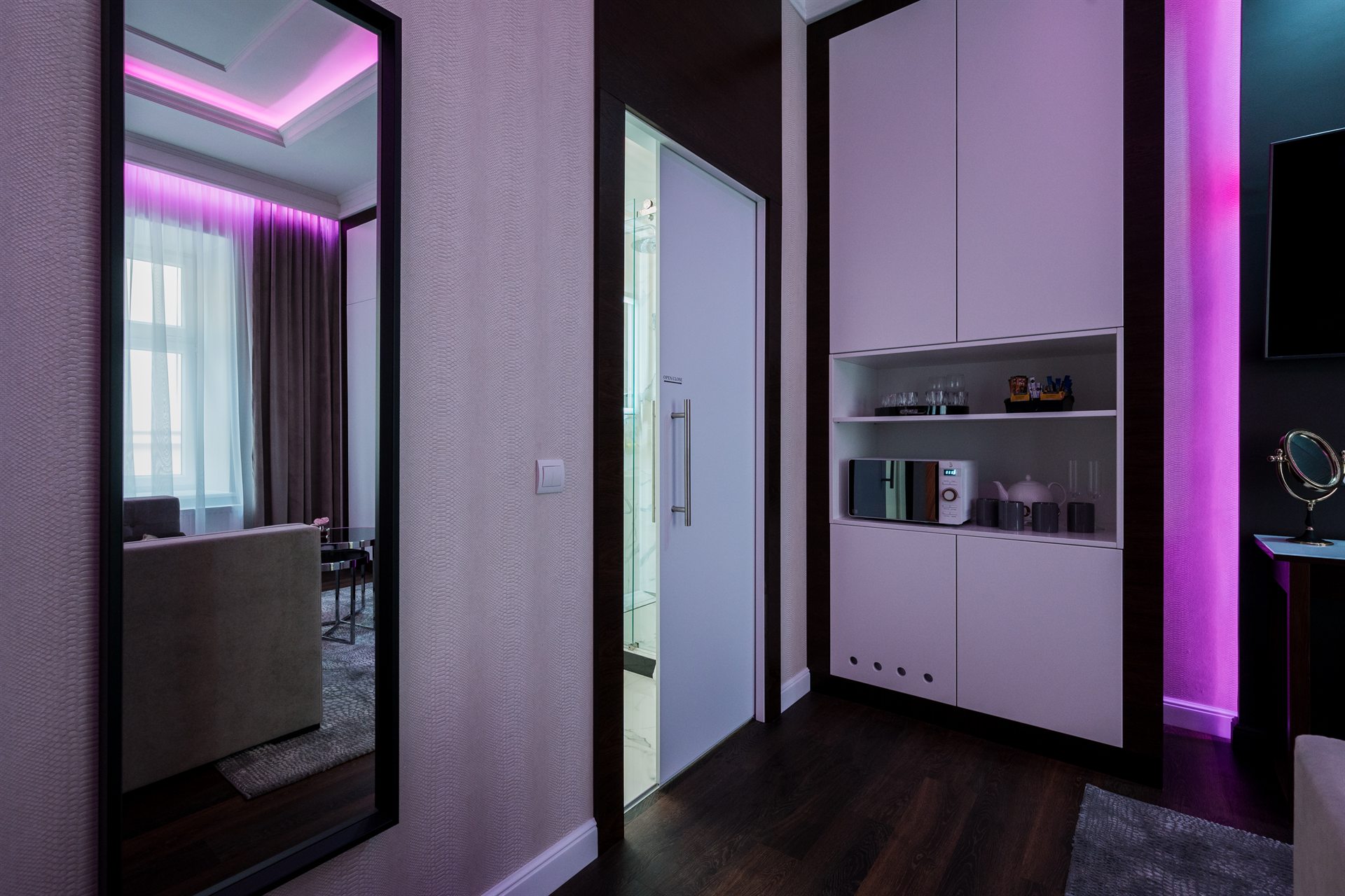 Nowoczesny pokój z lustrzanym odbiciem, oświetleniem LED i aneksem kuchennym