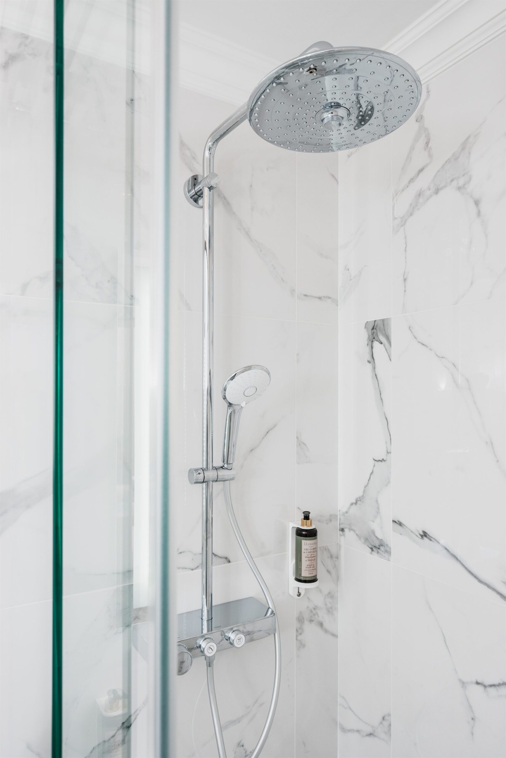 Nowoczesna kabina prysznicowa z chromowanym prysznicem i marmurowymi ścianami