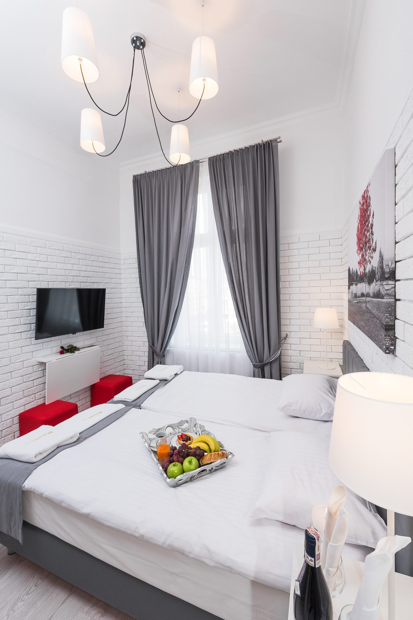 Nowoczesna sypialnia z białymi ścianami, lampą i poczęstunkiem na stole